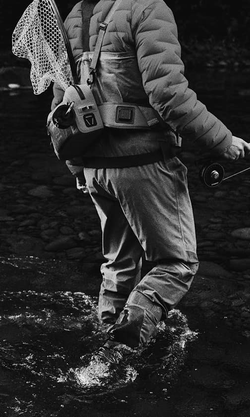Angler wading through a rocky stream