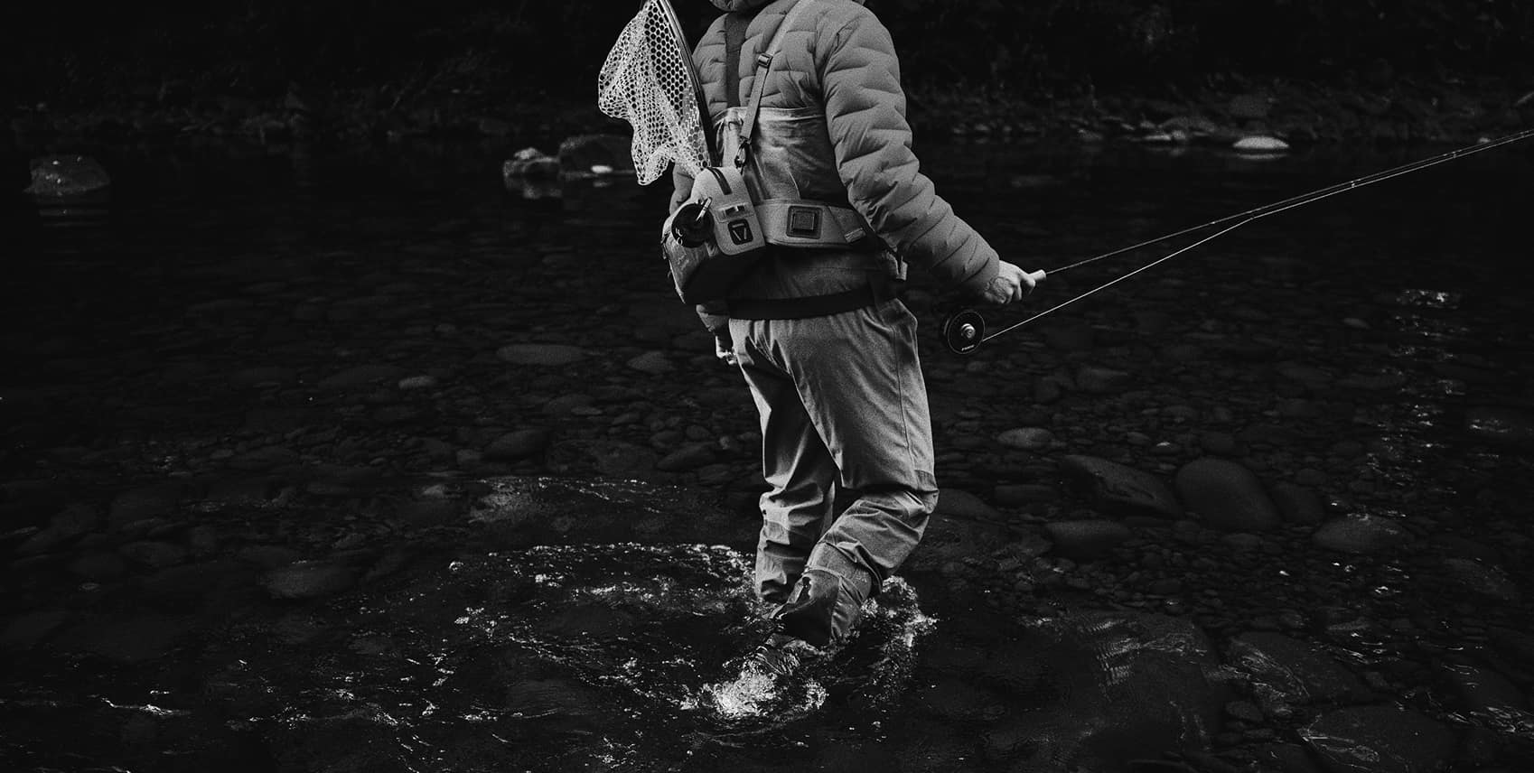 Angler wading through a rocky stream
