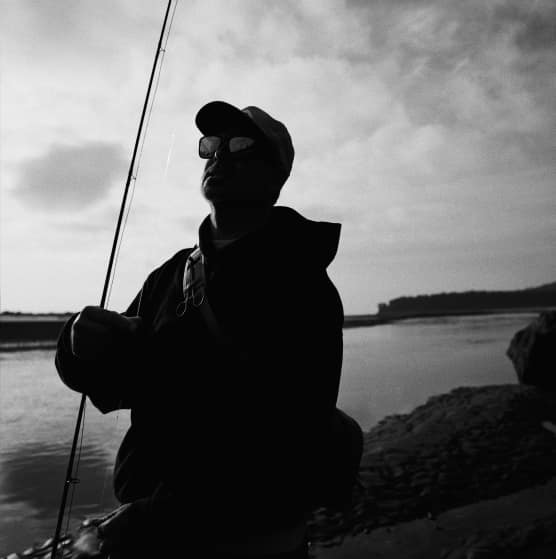 Angler silhouette holding a rod at dusk